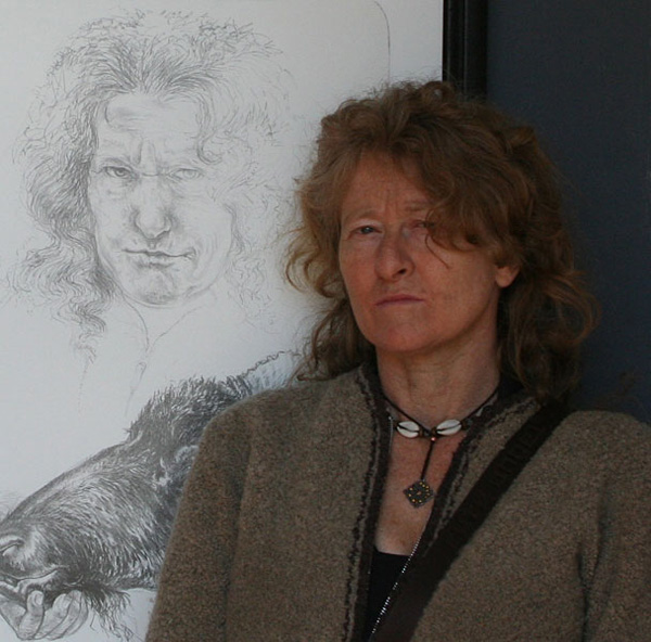Photograph of Diane Victor standing in front of her self-portrait lithograph