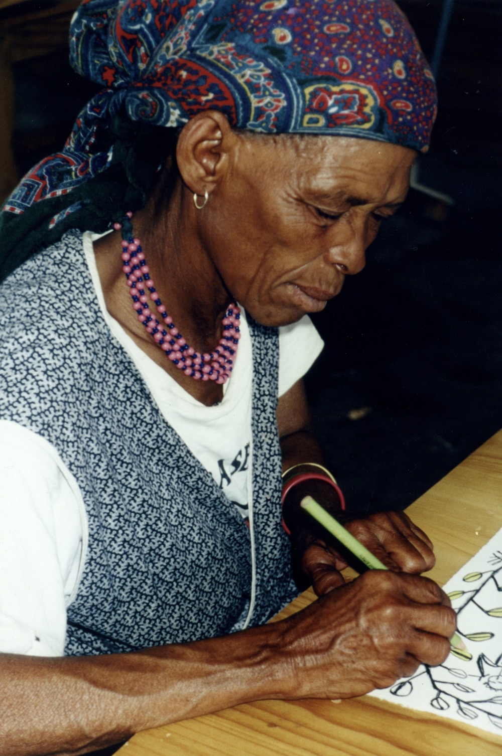 Ennie Coex'ae Bob working on her colour lithograph for the artists' book, Qauqaua