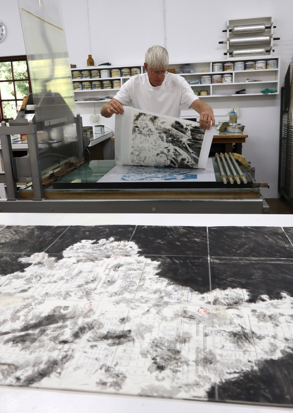Mark Attwood hand printing a limited edition lithograph by William Kentridge on a lithography press at The Artists' Press.