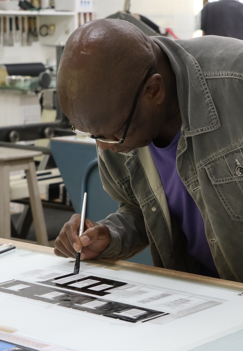 Sam Nhlengethwa painting ink onto grained film for his lithograph 6 De Beer Street