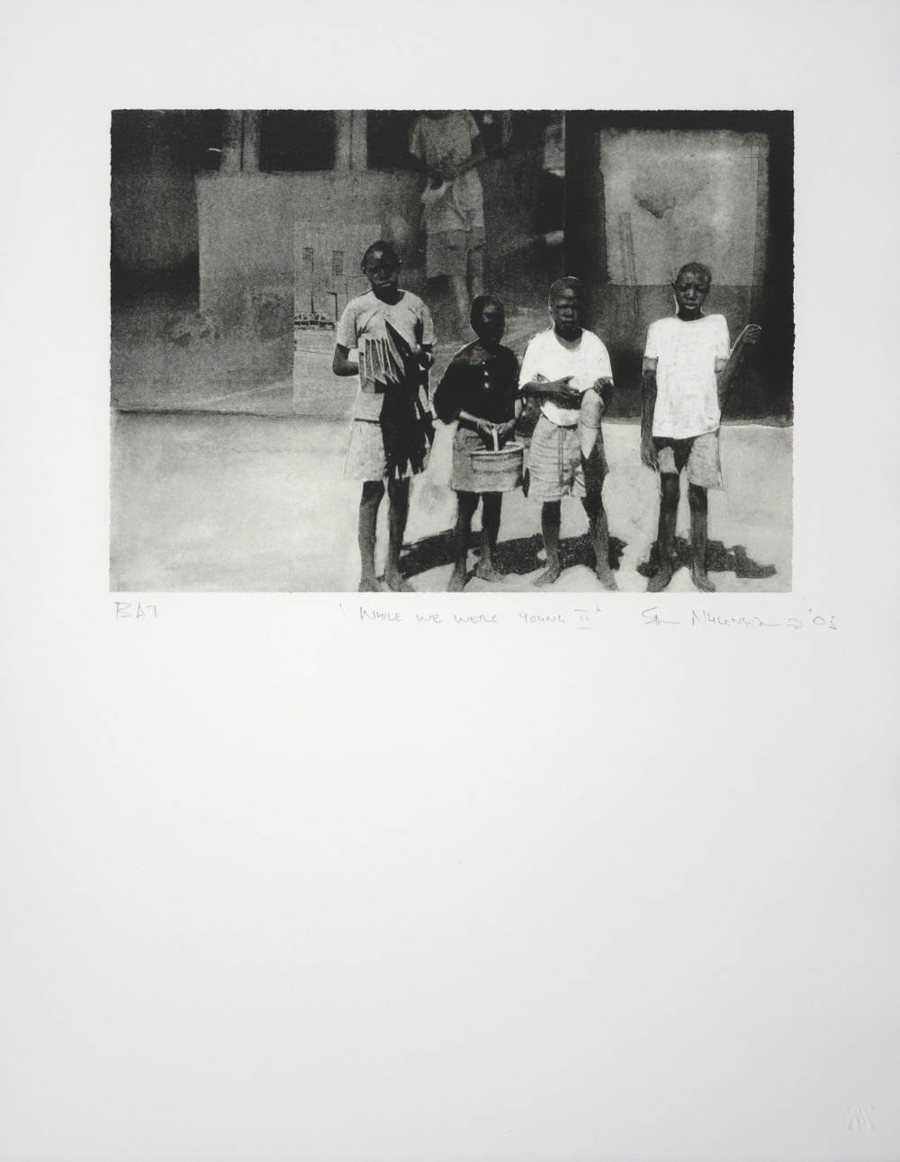 Group of four boys standing and looking out at viewer with built structures in background