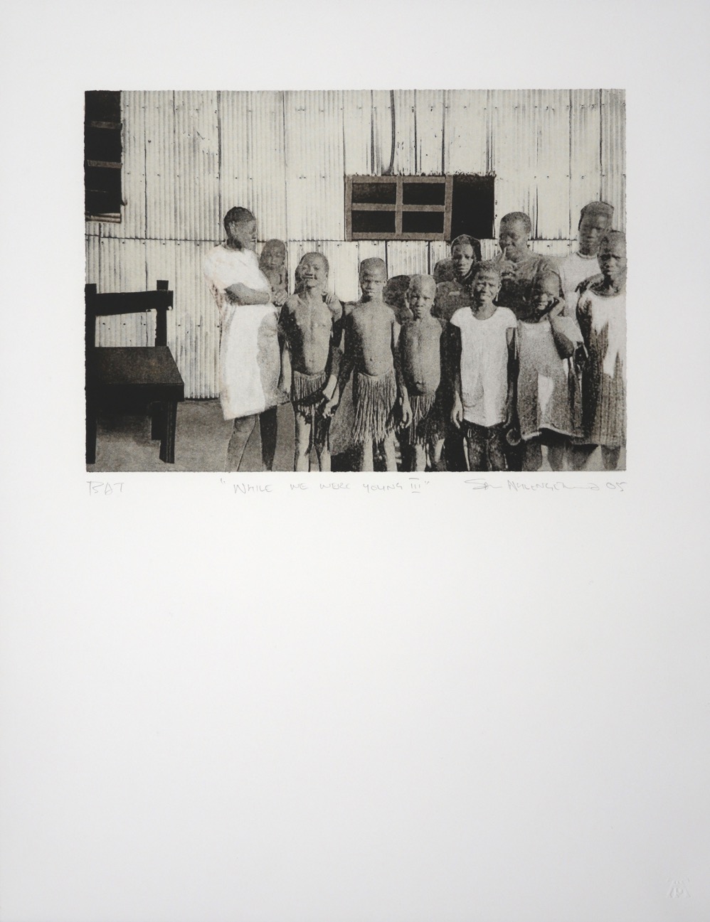 Group of children standing in front of corrugated iron walls of home with an abstracted chair on left