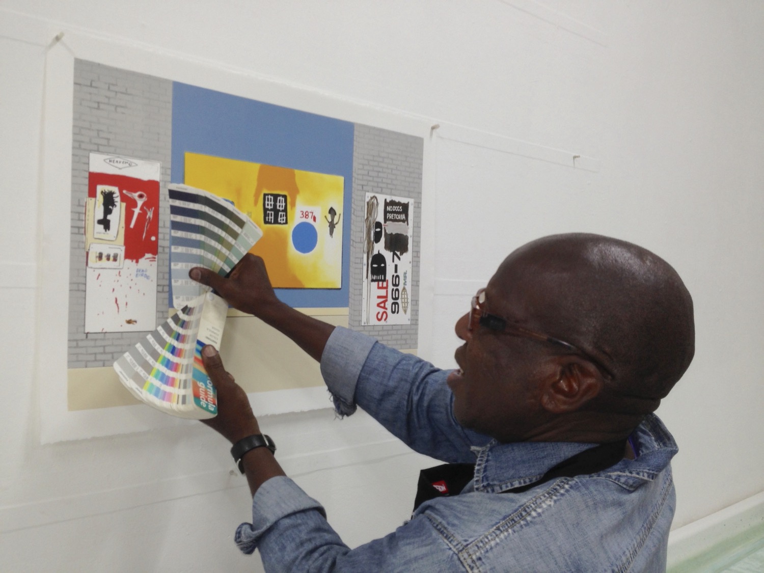 Artist Sam Nhlengethwa is selecting colours from a colour chart for a lithograph of his