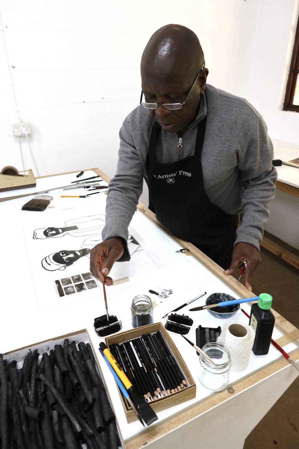 Sam Nhlengethwa working on grained film for Waiting Series of prints at The Artists' Press.