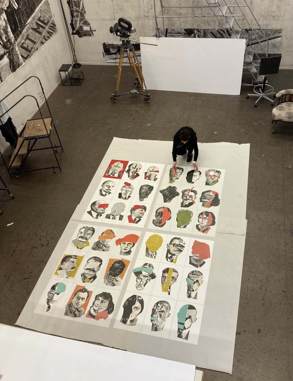 Elevated view looking down at 36 Soviet portraits by William Kentridge in his Johannesburg studio